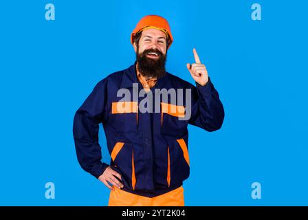 Male builder in hard hat and uniform pointing finger up having great idea and plan. Industrial worker in safety helmet pointing finger up. Building so Stock Photo
