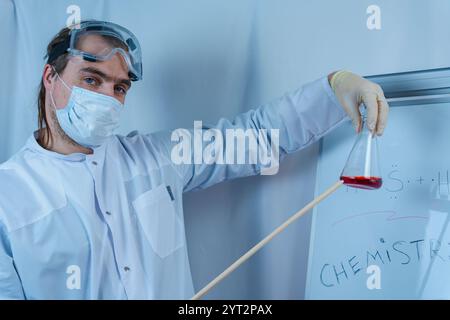 A scientist pours a colorful liquid from a test tube in a laboratory, surrounded by various lab equipment. The image captures the precision and focus Stock Photo