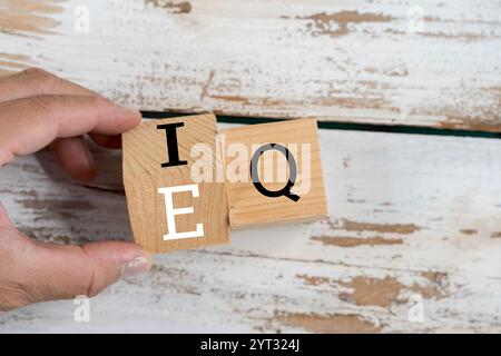 Business man hand change wooden cube block from IQ to EQ, balance between intelligence quotient and emotional intelligence concepts Stock Photo