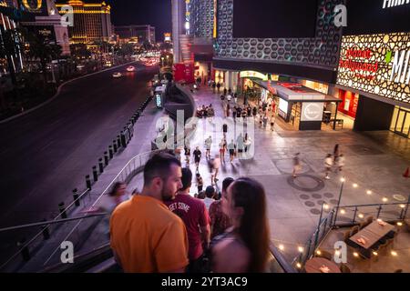 LAS VEGAS, AUGUST 21, 2024: Nighttime scene on Las Vegas Boulevard with tourists navigating elevators and neon-lit streets, showcasing the vibrant nig Stock Photo