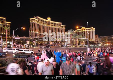 LAS VEGAS, AUGUST 21, 2024: Crowds of people explore the Las Vegas Boulevard (The Strip) at night with the illuminated Bellagio Hotel & Casino in the Stock Photo