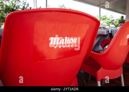VALENCIA, SPAIN - OCTOBER 13, 2024: Closeup of a Mahou beer logo on a red chair in a bar in Valencia. Mahou san miguel is a spanish beer producer. Stock Photo