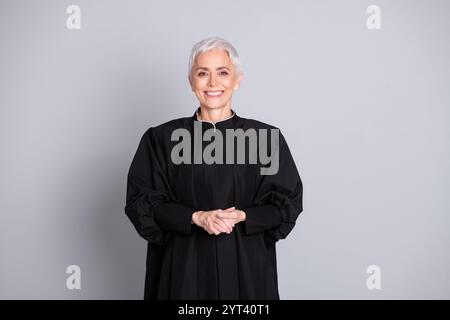 Photo of confident judge senior woman in black robe smiling verdict isolated grey color background Stock Photo