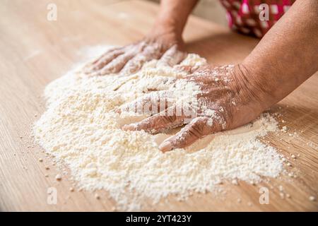 Chef preparing dough - cooking process. Bakers hand. Hands baker with flour in kitchen. Hands woman covered in flours. Women's hands, flour and dough Stock Photo