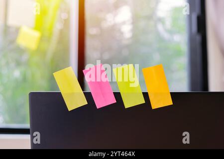 Colorful blank paper notes on a laptop at workplace with copy space to add your own text. Selective focus. Stock Photo
