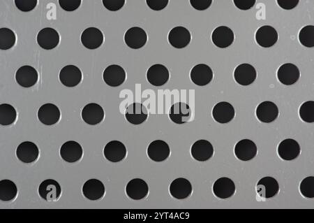 Perforations in a grey metal panel Stock Photo