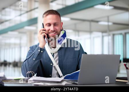 Broken Arm Injured Worker Compensation Coverage. Using Office Laptop Stock Photo
