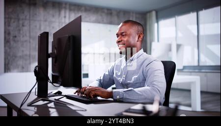 Employee Working On Desktop Computer In Home Office Stock Photo