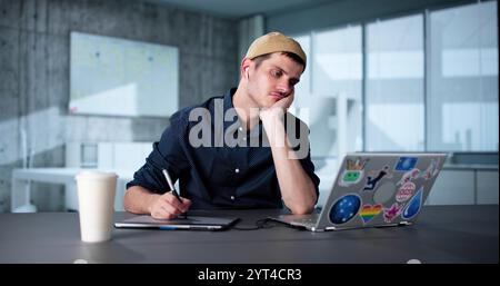 Tired Unhappy Graphics Designer Man Using Laptop Stock Photo