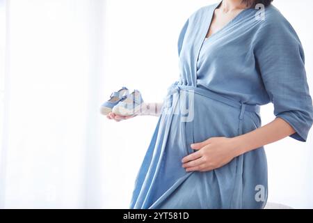 Woman holding baby's shoes Stock Photo