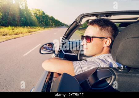 Happy convertible car driver looks at you smiling Stock Photo - Alamy