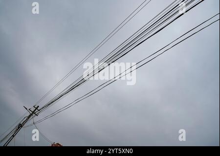 Power poles with many wires on a cloudy day. Stock Photo
