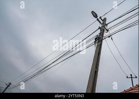 Power poles with many wires on a cloudy day. Stock Photo