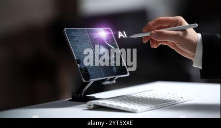 A businessman reaches out with a stylus toward a tablet, from which a holographic AI head and an AI icon emerge. This image represents the integration Stock Photo