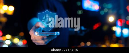 A hand holding a smartphone, highlighting a digital shield with a fingerprint icon. Represents mobile cybersecurity, biometric authentication, and sec Stock Photo