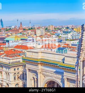 Triumphal Arch, the main entrance portal to Galleria Vittorio Emanuele II with the rooftops of Milan’s city center in the background, Italy. Stock Photo