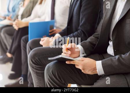 Close up group of formal wear smart people office lobby chair row sitting, working with documents Stock Photo