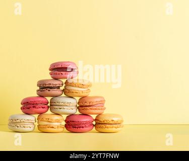 macaroons  fun colourful pyramid of pastel coloured  summer vibe soft yellow background n various flavors  with room fot copy space Stock Photo