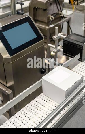 .Vertical photo white carton boxes on the production lines of packing and labelling machine. Stock Photo