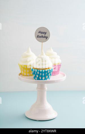 Three cupcakes for a birthday with buttercream on a cake stand Stock Photo