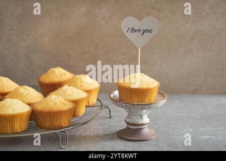 Vanilla cupcake with a declaration of love on a rustic cake stand Stock Photo