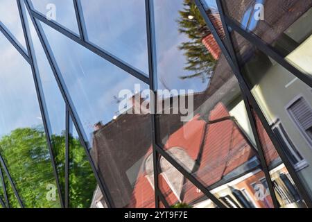 Houses are reflected in a facade made of glass blocks Stock Photo