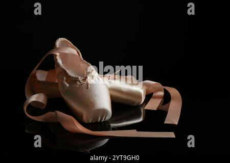 Pair of beautiful pointe shoes on black mirror surface Stock Photo