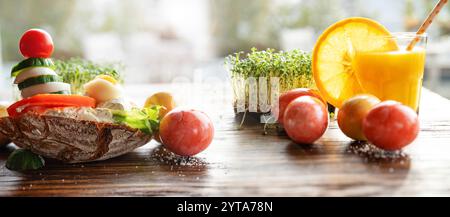Healthy breakfast with freshly squeezed orange juice and colorful easter eggs on rustic wooden table. Horizontal close-up with short depth of field. Stock Photo