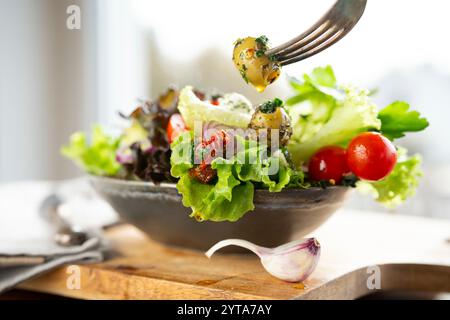 Colorful greek salad with olives and fresh ingredients in a ceramic bowl. Fork with olive from above. Healthy nutrition concept for fitness and spring diet. Stock Photo