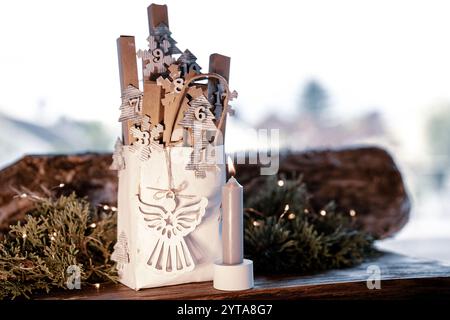 Homemade advent calendar made of cardboard. Small cardboard boxes in a paper bag decorated on rustic wood. Sustainable christmas packaging. Background for a eco friendly christmas surprise. Stock Photo