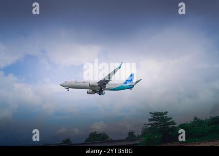 Commercial jet plane flies low over Balikpapan beach as it lands, October 10, 2024, East Kalimantan, Indonesia Stock Photo
