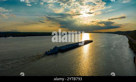 JULY 2, 2023, ALTON IL., USA - barge travels North on Mississippi from Alton Illinois at sunset Stock Photo