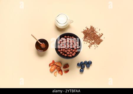 Bowl with cereal breakfast, milk and ingredients on beige background Stock Photo