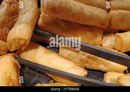 A container of fried spring rolls from a buffet restaurant Stock Photo