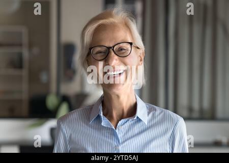 Smiling aged professional woman, corporate head shot office portrait Stock Photo