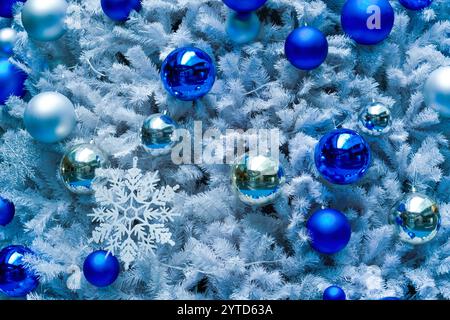 Christmas tree with silver New Year toys, blue and silver balls, glowing snowflakes. Stock Photo