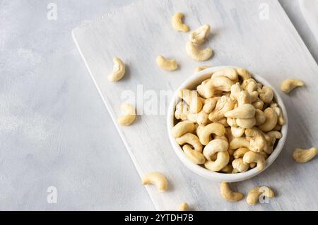Raw cashew nuts in bowl or burlap sack on rustic table Healthy vegetarian snack, Anacardium occidentale Stock Photo