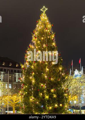 Decorated large outdoor Christmas tree with colorful lights and ornaments Stock Photo
