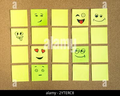 self adhesive office notes with different face expression on cork board as abstract concept photo Stock Photo