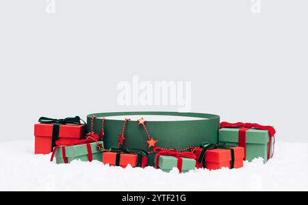 Empty green round gift box in the snow isolated on a blue background. Christmas background for design. Template, mockup. Space for text. Stock Photo