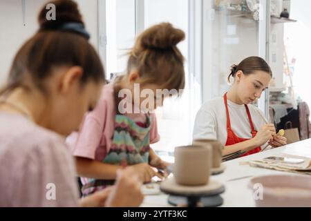Artistic pottery class with children and adults engaged in creative activities Stock Photo