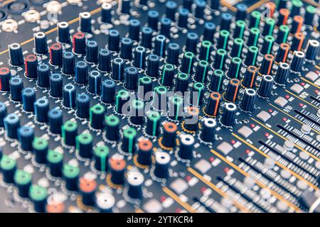 Close up view of a mixing console with numerous knobs and faders, ideal for music production or live sound engineering Stock Photo