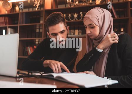 A business team of young man and Muslim woman working together on the project planning strategy in the modern office or Arabic college students study Stock Photo