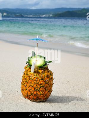 Tropical drink - pineapple fruit cocktail in white sand beach paradise - Caribbean island Dominican Republic Cayo Levantado blue green ocean sea water Stock Photo