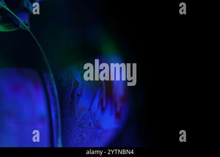 Purple liquid pattern on black background, fluid motion, dark horror background, liquid in macro, fantastic smooth motion Stock Photo