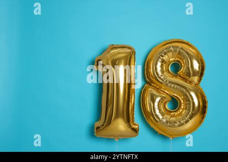 Coming of age party - 18th birthday. Number shaped balloons on light blue background, space for text Stock Photo