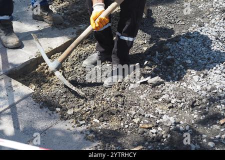 Workers are engaged in road repair with various tools and materials Stock Photo