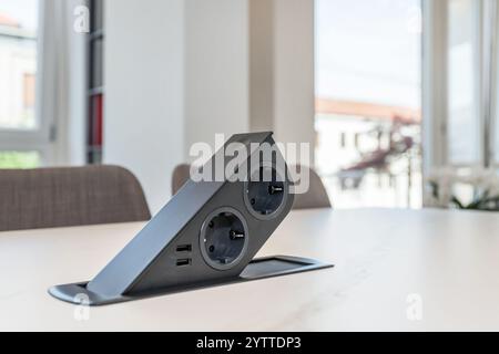 Table built-in socket. Fixed retractable power strip for home and office.  New technology. Modern style. Stock Photo