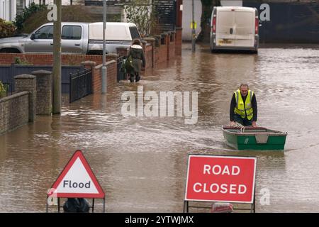 A flood warden pushes a boat in floodwater in Greyfriars Avenue in Hereford, Herefordshire, after Storm Darragh hit the UK and Ireland. Picture date: Sunday December 8, 2024. Stock Photo