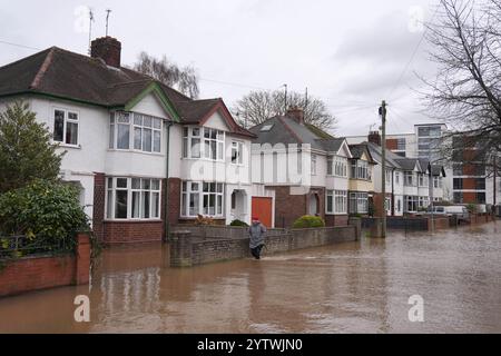 A person walks through floodwater in Greyfriars Avenue in Hereford, Herefordshire, after Storm Darragh hit the UK and Ireland. Picture date: Sunday December 8, 2024. Stock Photo